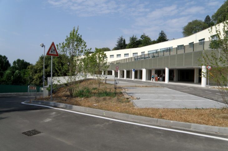Area parcheggio esterna della struttura, con spazi di sosta e percorso pedonale adiacente.